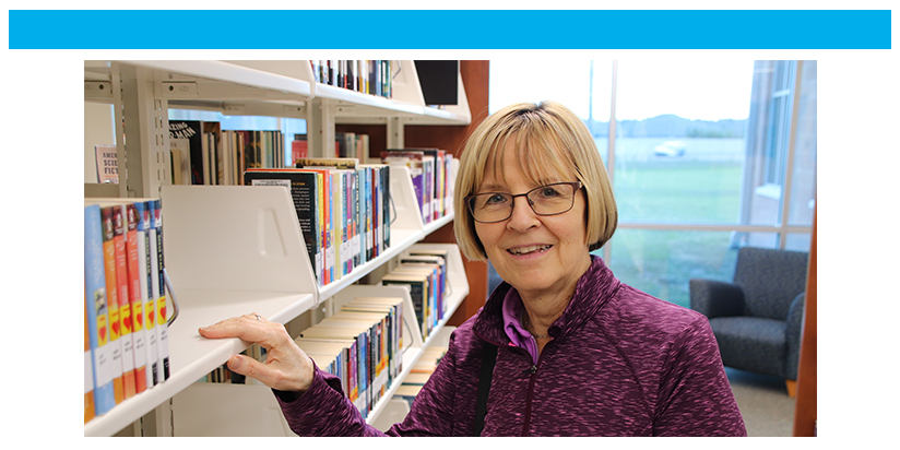 Older woman posing at bookshelf