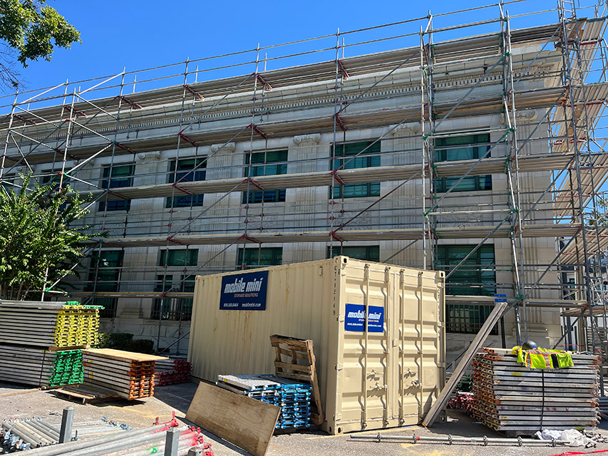 Side of building with scaffolding and construction materials